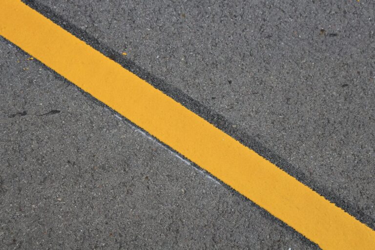 A bold yellow line dividing grey asphalt — representing the clear boundary between SRE and Platform Engineering responsibilities